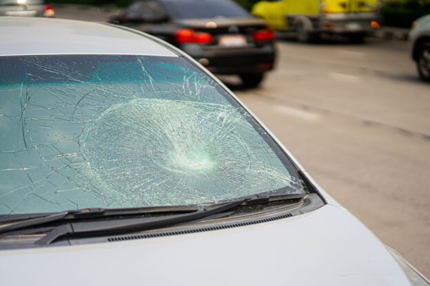 A car with a shattered windshield as if it was hit by a stone gets replaced by American Eagle Auto Glass